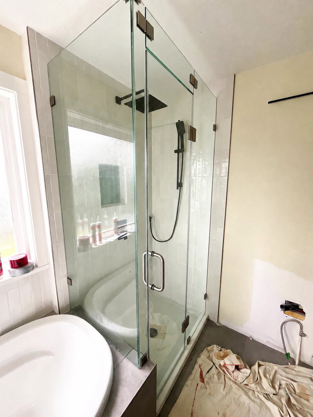 Completed frameless shower glass enclosure with dark hardware